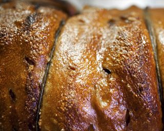 Die saftige und herzhafte Porchetta in Scheiben, um dann zwei Scheiben vom Weißbrot aus dem Holzofen damit zu belegen