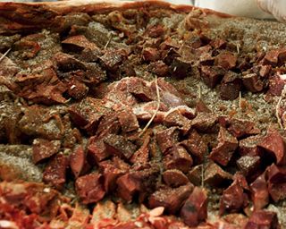 La lavorazione della porchetta Cariani: il maiale viene insaporito con spicchi di aglio, sale, pepe indiano, rosmarino e finocchio selvatico